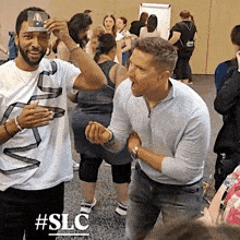 a group of people are standing in a room with the hashtag #slc