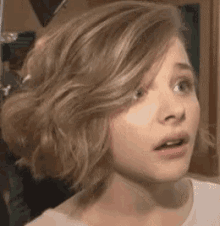a close up of a woman 's face with a surprised expression .