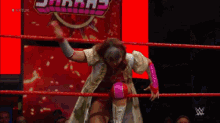a woman is standing in a wrestling ring with a sign that says sharray