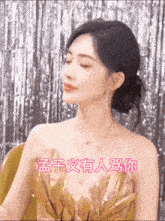 a woman in a gold dress with chinese writing on her chest