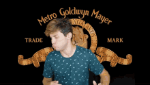 a man in front of a metro goldwyn mayer logo