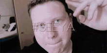 a close up of a man 's face with the words #seeya written above it
