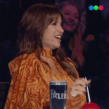 a woman is holding a straw next to a can that says got talent on it