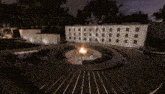 a fire pit in the middle of a circle with a white wall behind it