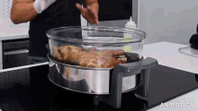 a chicken is being cooked in a glass container on a stove top with the words made in animatica visible