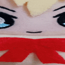 a close up of a stuffed animal with a red bow around its neck .