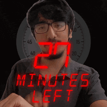 a man wearing glasses stands in front of a clock that says 27 minutes left