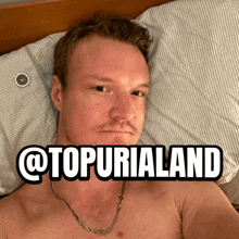 a shirtless man is laying on a bed with a sticker that says @topurialand