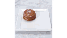a white plate topped with a cake and a scoop of ice cream .
