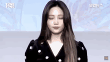 a woman is standing on a stage in front of a blue screen .
