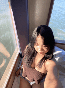 a woman is taking a selfie in front of a window overlooking the water