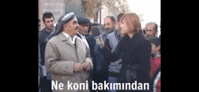 a woman is holding a microphone in front of a group of people with the words ne koni bakimindan written on the bottom