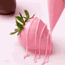 a strawberry covered in pink icing is being decorated