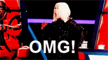 a woman in a black dress stands in front of a screen that says omg