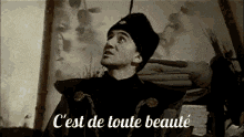 a black and white photo of a man with the words " c'est de toute beaute " written below him
