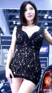 a woman in a black lace dress is standing in front of a sign that says 3d