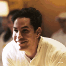 a man in a white shirt is smiling with rbd.gif written on the bottom