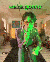 a man singing into a microphone with the words " we 're gonna " behind him