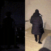 a silhouette of a person standing in a dark room next to a silhouette of a person walking down stairs
