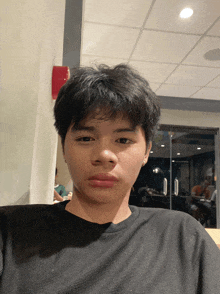 a young man wearing a black shirt is taking a selfie