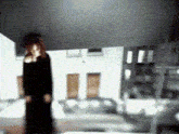 a blurred image of a woman standing in front of a building