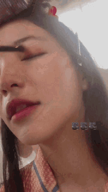 a close up of a woman 's face with her eyes closed and the number 88 on her neck