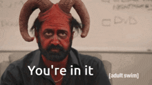 a man with horns and red paint on his face says " you 're in it "