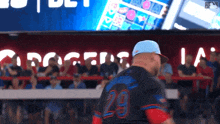 a baseball player wearing a number 29 jersey stands in the dugout