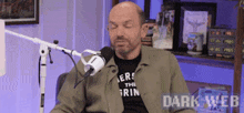 a bald man is sitting in front of a microphone .