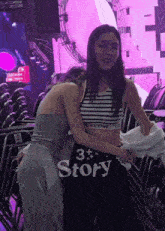 a woman in a celine crop top hugging another woman
