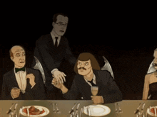 a group of people are sitting at a table with plates of food and silverware