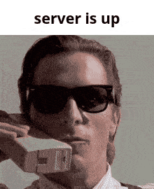 a man wearing sunglasses is holding a piece of paper in his mouth with the words server is up below him
