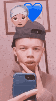 a young man taking a selfie with a blue heart and emojis on his hat