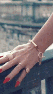 a close up of a woman 's hand with a bracelet and rings on it