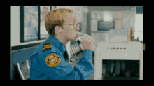 a man in a tsa uniform is drinking from a bottle