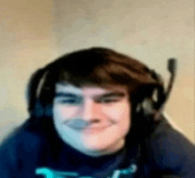 a man wearing headphones and a microphone is smiling for the camera .