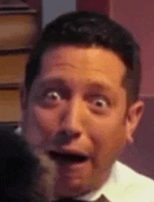 a man in a suit and tie is making a surprised face .