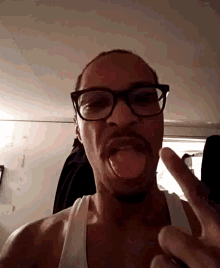 a man wearing glasses and a mustache is sticking his tongue out