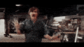 a blurry picture of a man in a garage with his hands up