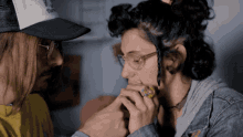 a man in a trucker hat holds a woman 's hand in a close up