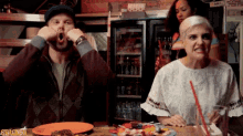 a man and a woman are sitting at a table with a sign that says gracked on it