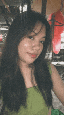 a woman in a green top takes a selfie
