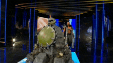 a man standing next to a statue with a shield and skulls on it .