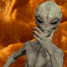 a grey alien with a star trek necklace on his neck