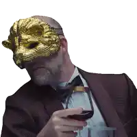 a man with a gold mask on his face holds a glass of wine