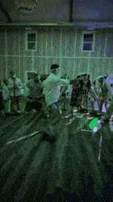 a group of people are dancing in a dark room