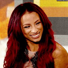 a woman with red hair is smiling in front of a yellow background .