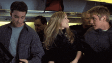 a man in a plaid shirt stands next to a woman in a black shirt