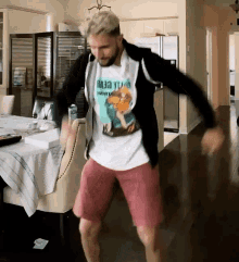 a man is dancing in a living room wearing a t-shirt that says ' nasa ' on it