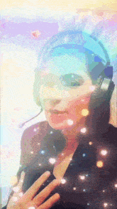 a woman wearing headphones and a microphone is standing in front of a rainbow background .